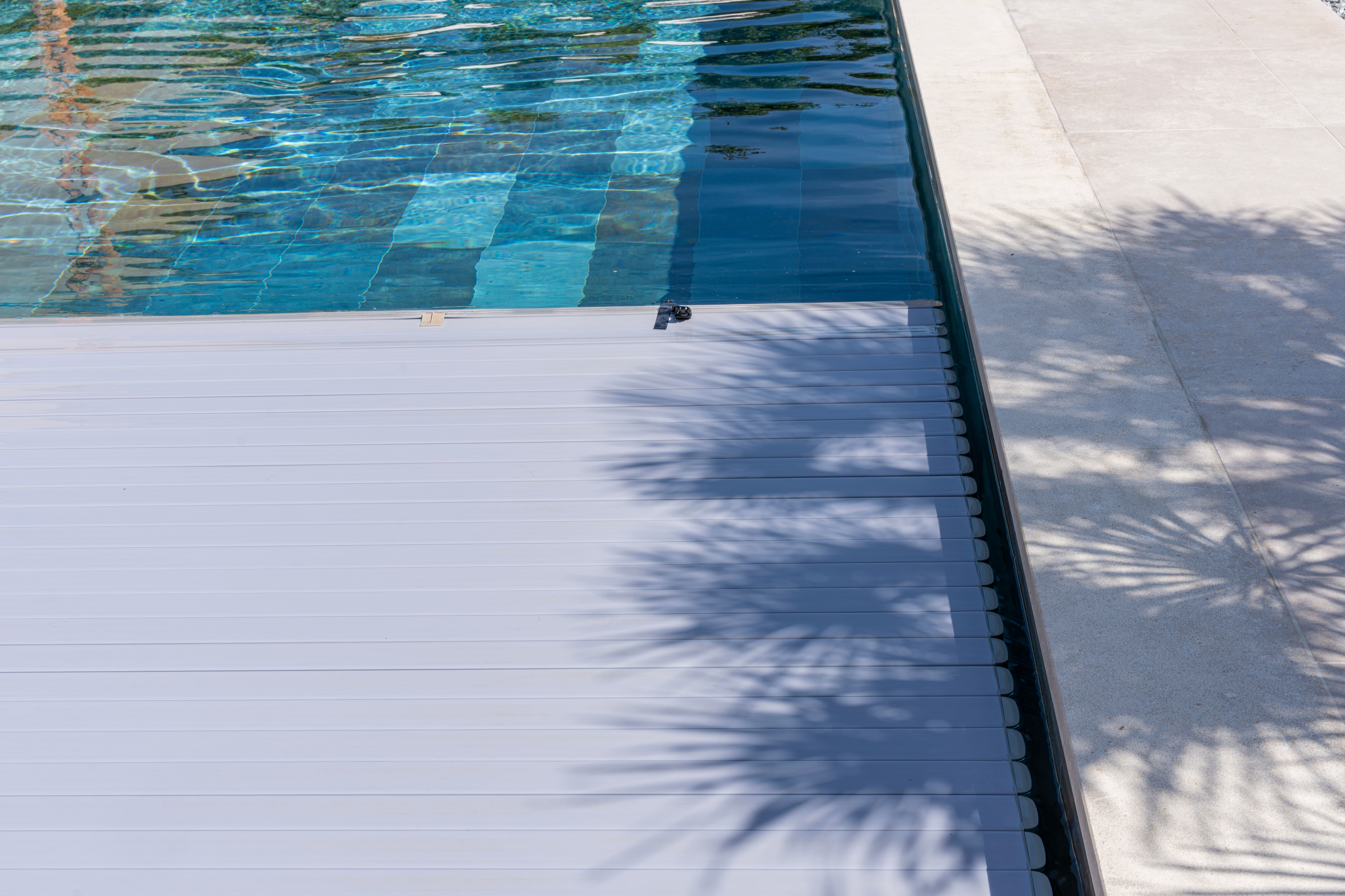 Volet roulant de piscine enroulé avec système motorisé en bout de bassin