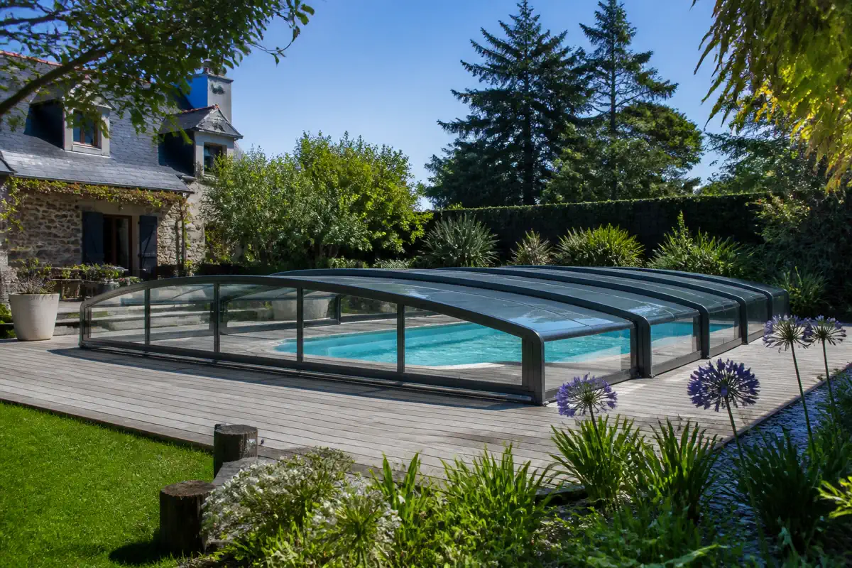 Un abri de piscine Abrisud bas et discret, intégré aux abords du bassin.