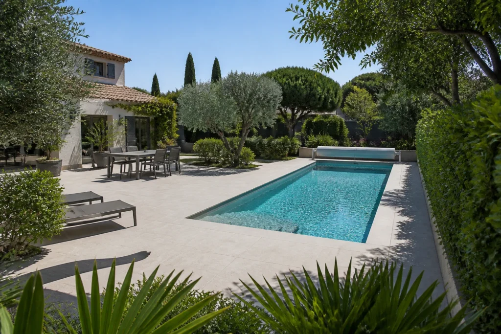 Piscine 8 x 4 m intégrée harmonieusement au jardin pour illustrer la taille idéale d’une piscine