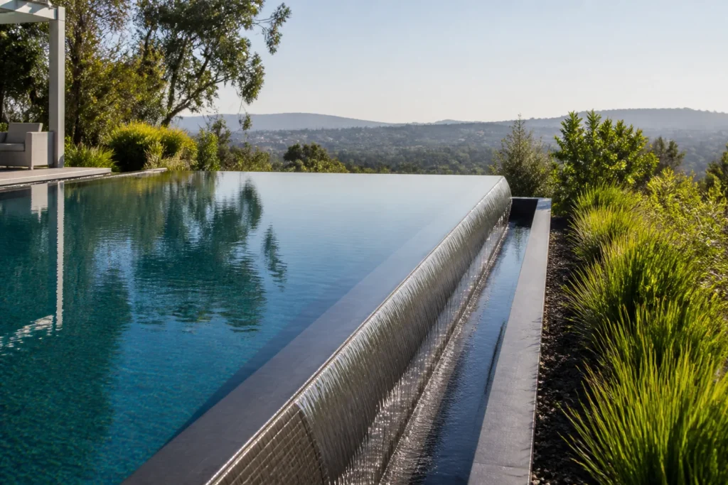 Piscine à débordement moderne avec débordement régulier vers un paysage dégagé